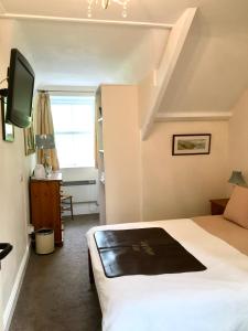 a hotel room with a bed and a tv at Rosalie Guest House in Penzance