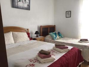 a bedroom with two beds with towels on them at Casa J Dias in Nordeste