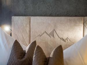 a bed with a picture of mountains on the wall at Alpengasthof Gern Alm in Pertisau