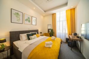 ein Schlafzimmer mit einem großen Bett mit einer gelben Decke in der Unterkunft Elenas Rooms & Apartment in Zagreb