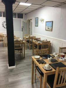 a dining room with wooden tables and chairs at Kingscliff in Blackpool