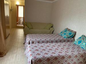 a bedroom with a bed and a couch in it at Бухточка in Gelendzhik