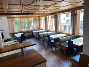 ein Esszimmer mit Tischen, Stühlen und Fenstern in der Unterkunft Chalet Prantl in Sölden