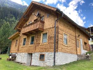 a large wooden house with a wooden roof at Gletscher Chalet in Flattach