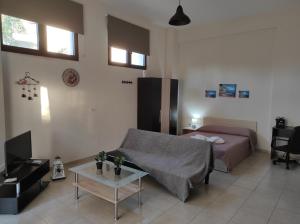 a living room with a bed and a couch at John's Apartments in Nea Michaniona