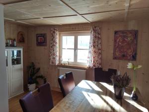 ein Esszimmer mit einem Tisch und einem Fenster in der Unterkunft Allgäu Apartment Rose im OG in Grünenbach