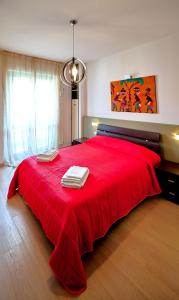 a bedroom with a red bed with towels on it at Farini Apartment in Milan