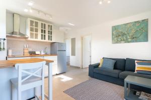 een keuken en een woonkamer met een blauwe bank bij Apartment with a view in Rovinj