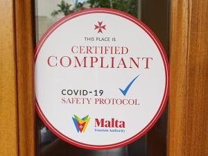 una señal de conformidad certificada en una puerta en Rivotorto Retreat House, en Birkirkara