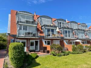 een groot bakstenen gebouw met balkons erop bij Großzügige Familienwohnung - mit grossen Esszimmer in Juist