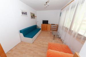 sala de estar con sofá azul y TV en Řadovka Bílá, en Bílá