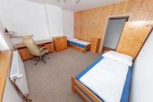 1 dormitorio con cama, escritorio y silla en Řadovka Bílá, en Bílá