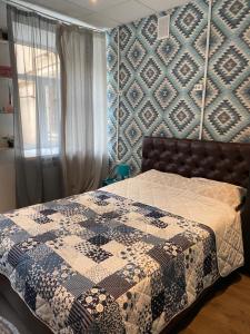 1 dormitorio con 1 cama con edredón en ULA Hostel, en San Petersburgo