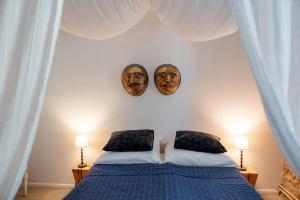 um quarto com uma cama com duas máscaras na parede em Káli44 Vendégház em Révfülöp