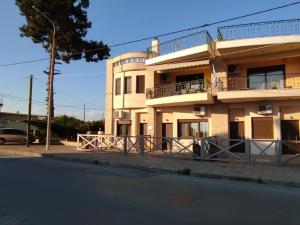 a large white building with a balcony on a street at John's Apartments in Nea Michaniona