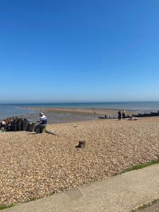um grupo de pessoas sentadas na praia em The Beach Retreat Whitstable em Kent