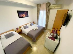 Cette chambre comprend deux lits et une télévision. dans l'établissement Apartments Stari Ribar, à Budva