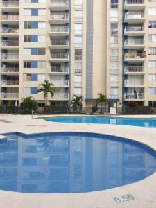 a large swimming pool in front of a building at Puerto Azul Club House Apartamento Familiar in Ricaurte