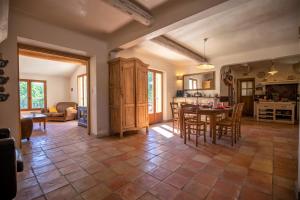 a kitchen and living room with a table and chairs at La Bastide des Milles in Apt