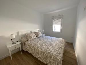 ein weißes Schlafzimmer mit einem Bett und einem Fenster in der Unterkunft Casa Vileros in L'Ampolla