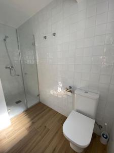 ein weißes Bad mit einem WC und einer Dusche in der Unterkunft Casa Vileros in L'Ampolla