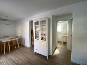 eine Küche und ein Esszimmer mit einem weißen Schrank in der Unterkunft Casa Vileros in L'Ampolla