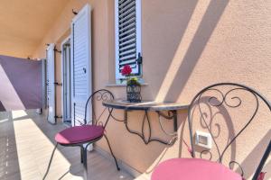 a balcony with two chairs and a table and a window at Apartments Jo in Senj