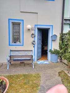 阿巴雷拉島的住宿－RESIDENZA DI SANDRA，坐在房子外的门边的长凳