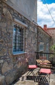 2 sillas y una mesa fuera de un edificio de piedra en Samaradiko, en Kondiás