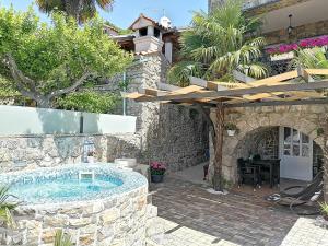 uma casa de pedra com uma piscina e um pátio em Apartmani Brajutovci 26 em Kornic