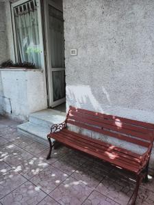 un banco rojo sentado frente a un edificio en casa giardino, en Scauri