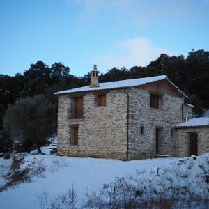 un edificio de piedra con techo cubierto de nieve en Casa rural EL PAJAR DE TEJEDOR, en Mondot