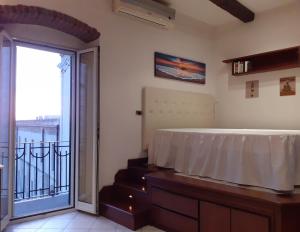 a room with a bed and a balcony with a sliding glass door at Domida Apartment in Bari