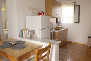 eine Küche mit einem Tisch und einem weißen Kühlschrank in der Unterkunft Ayerina First floor Apartment in Arillas