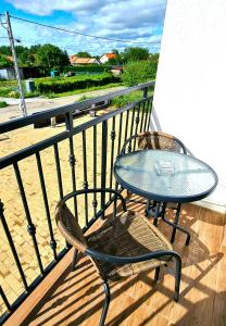 - Balcón con mesa de cristal y 2 sillas en Székely-Lak Apartman Hegykő, en Hegykő