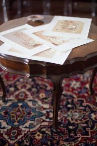 una mesa de madera con papeles encima de una alfombra en B&B Palazzo de I Mysteri, en Campobasso