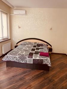 a bedroom with a bed with a quilt on it at дача in Odesa