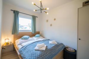 a bedroom with a bed with two towels on it at MyFlat Diana Family Apartment in Siófok +21 photos