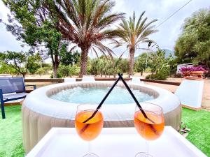 - deux verres à vin sur une table en face d'une piscine dans l'établissement Villa Bianca, à Tertenìa