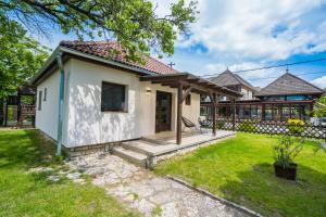 a small white house with a grass yard at MyFlat Diana Family Apartment in Siófok