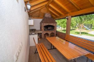 a porch with a wooden table and a fireplace at Oasis of peace in Bihać