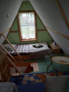 a room with two beds and a sink in a attic at Domek pod lasem in Maniowy
