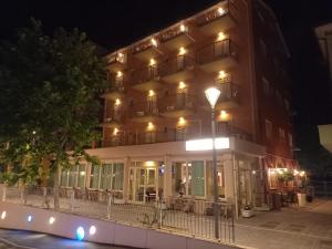 hotel w nocy z oświetleniem na fasadzie w obiekcie Hotel Serafini w mieście Misano Adriatico