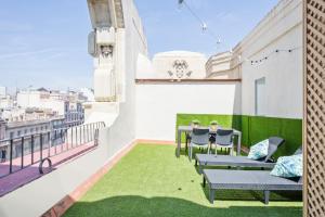 a balcony with a table and chairs on a roof at Blau Atic Apartment in Barcelona
