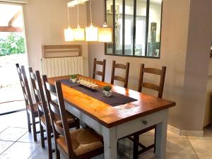 een eetkamer met een houten tafel en stoelen bij Résidence Alpha Centauri in Carcassonne