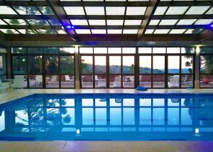a swimming pool in a building with a large window at Sky Borges Hotel Alpenhaus - Gramado in Gramado