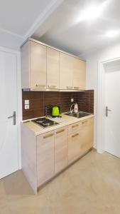 a kitchen with wooden cabinets and a sink at Seaflows Apartments #1 in Paralia Katerinis
