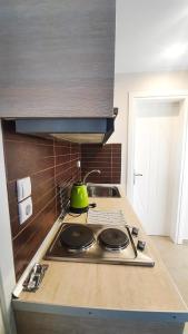 a kitchen with a stove with a green tea kettle on it at Seaflows Apartments #1 in Paralia Katerinis