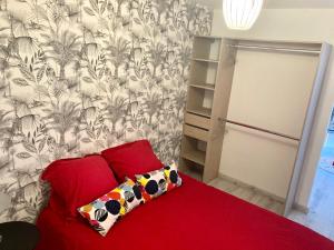 a bedroom with a red couch with a red pillow at Bel Air 1 in Fougeré