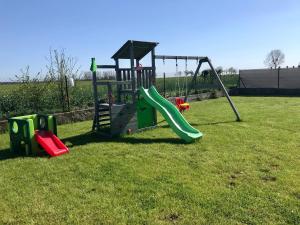 a playground with a slide in the grass at Domki Akacjowe Zacisze in Puck